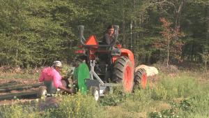 Brooke and Keia planting vegetable starts from the tractor